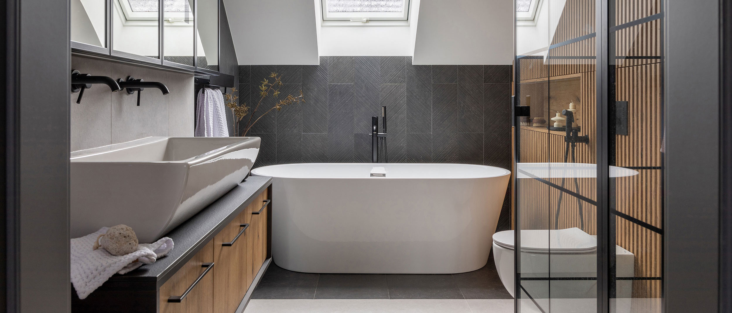 Stylish interior of bathroom with bathtub, shower, towels and ot